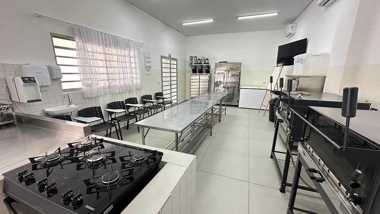 Cozinha-escola do CCP do Centro com fogão, bancadas de aço, fornos e cadeiras