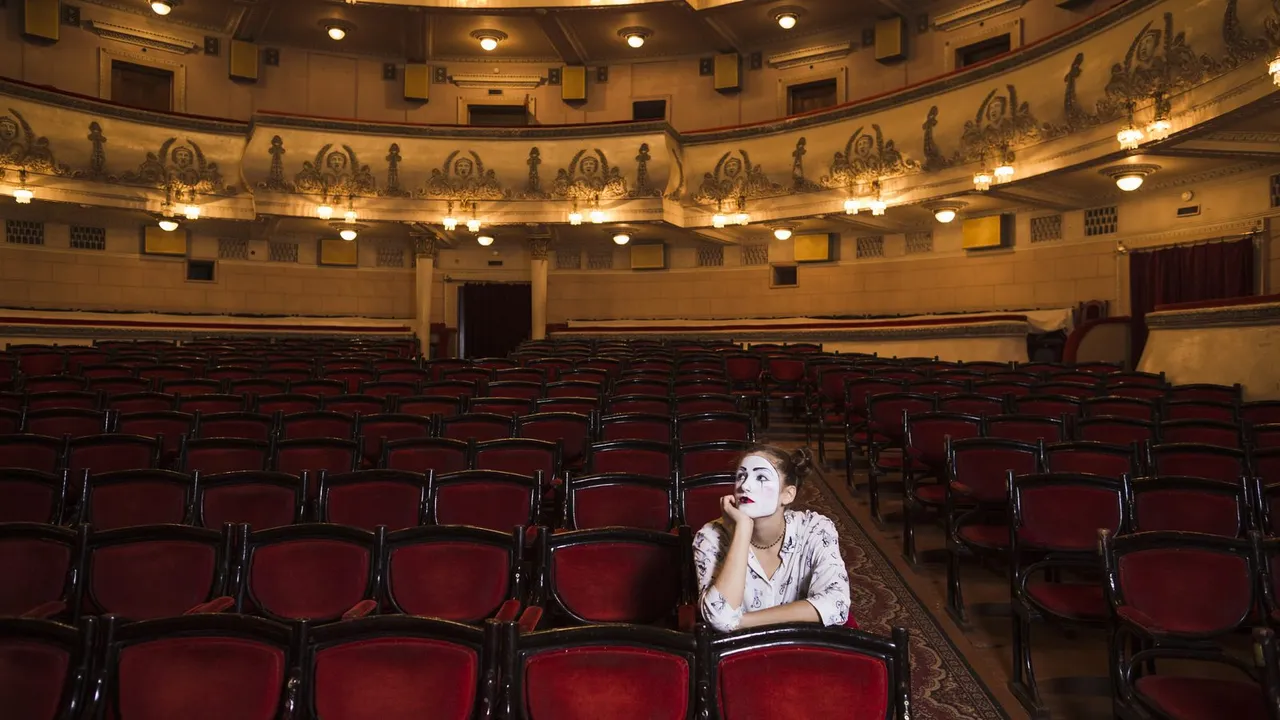 Interior de um teatro clássico com poltronas e camarotes